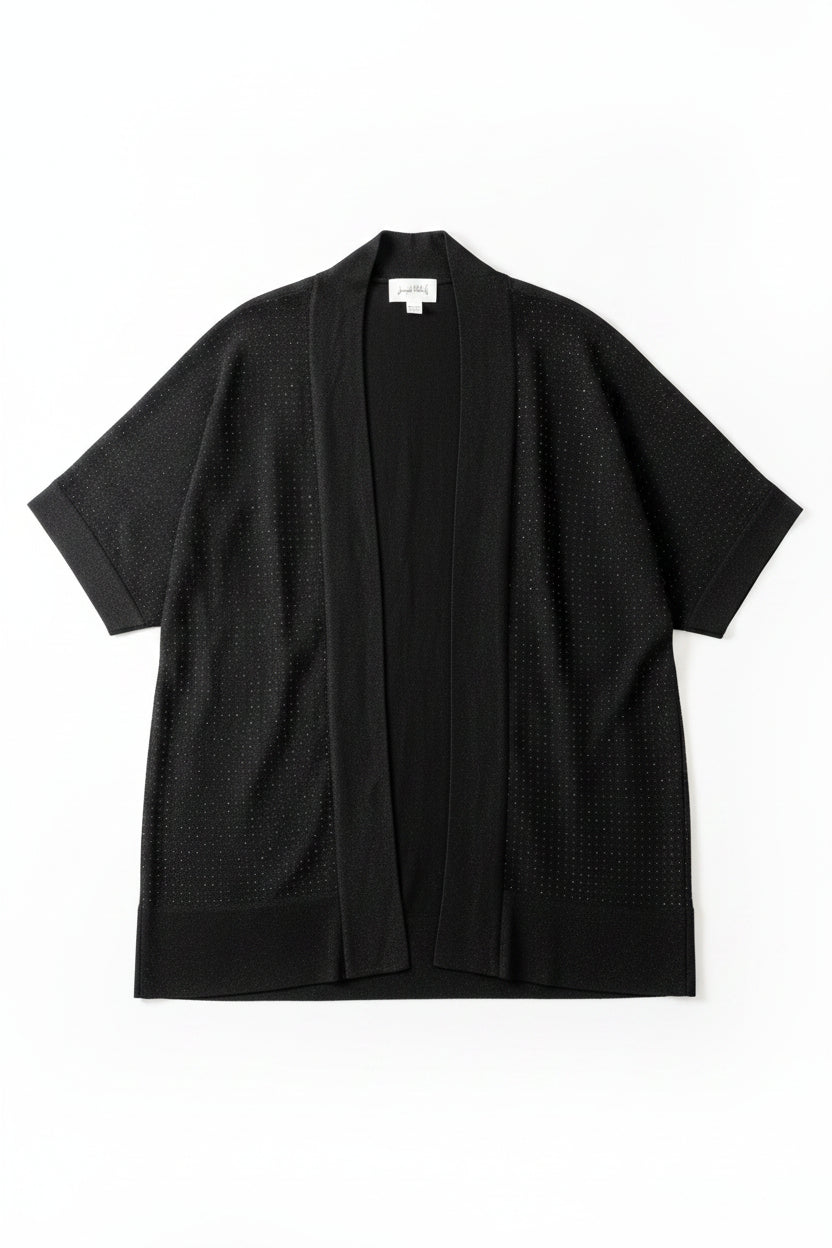 A black open-front cardigan sweater with three-quarter sleeves hanging on a black hanger against a textured off-white wall. The cardigan has a subtle dotted texture and features a hangtag and a white size label.