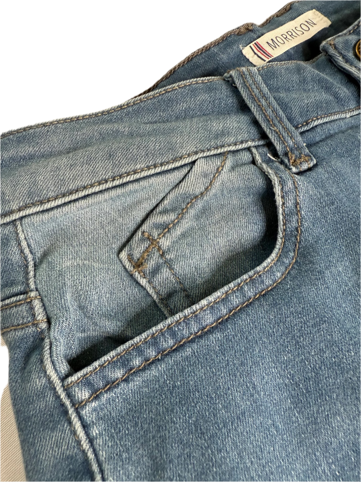 Close-up of blue jeans with a Morrison label on a beige background