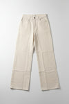 Beige pants hanging on a black hanger against a white wall.