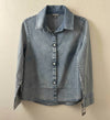 Denim shirt on a hanger against a beige wall