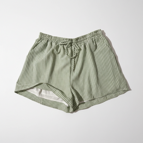 Green checkered shorts on a white surface with a blurred background