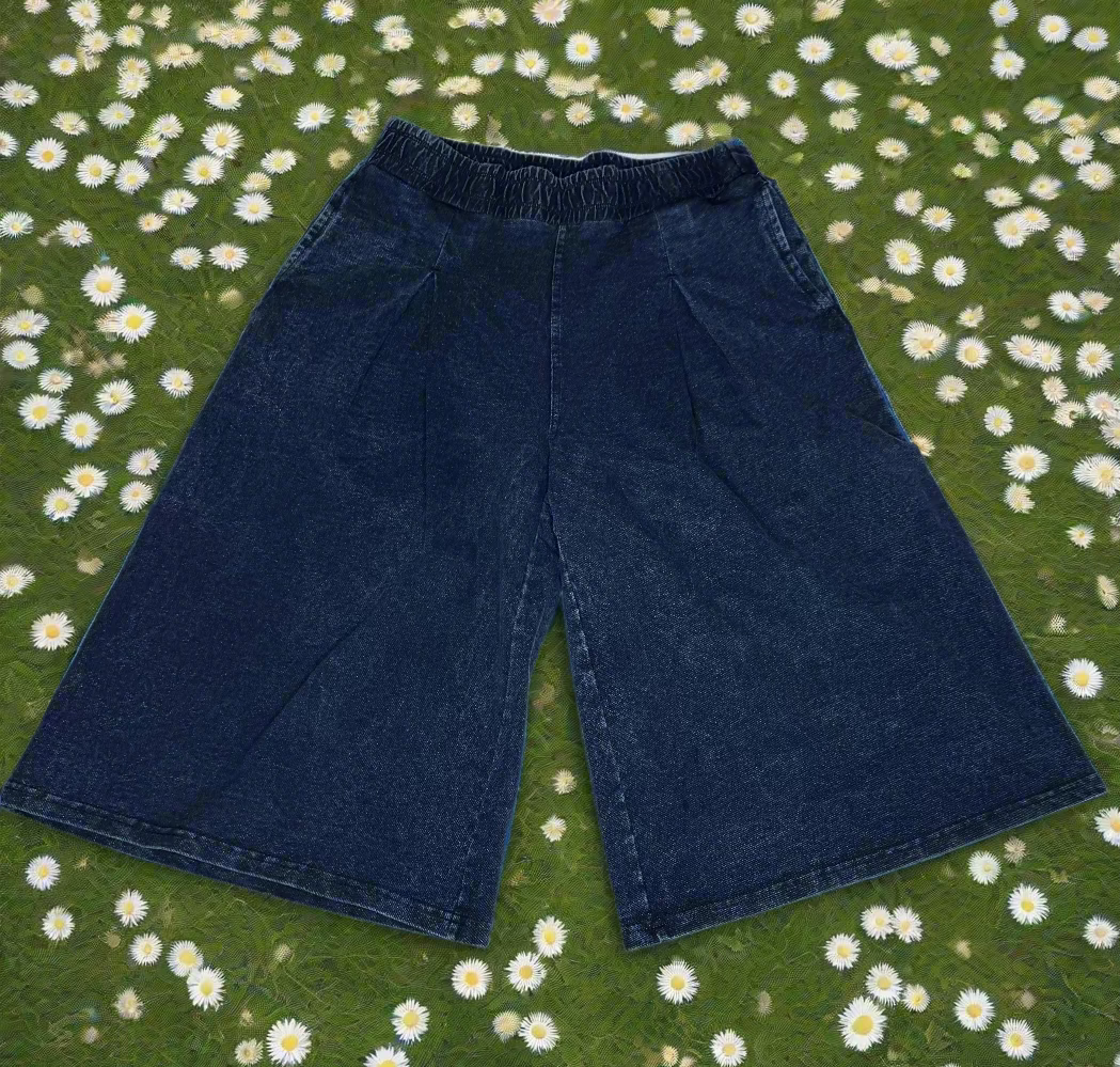 Pair of blue denim- looking sweat pant material shorts on a white surface