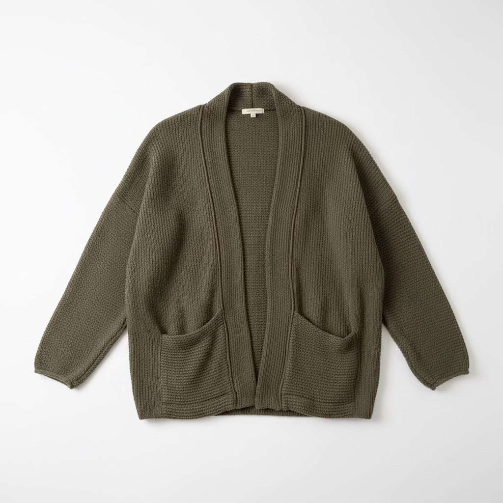 An olive green waffle-knit open-front cardigan sweater hanging on a black hanger against a textured off-white wall.