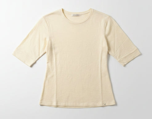 Beige t-shirt on a hanger against a plain wall