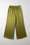 Green skirt hanging on a hanger against a white wall