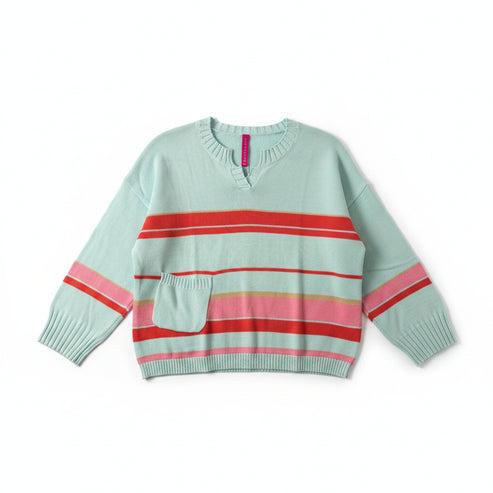 Light blue sweater with red and pink stripes on a hanger against a beige wall.