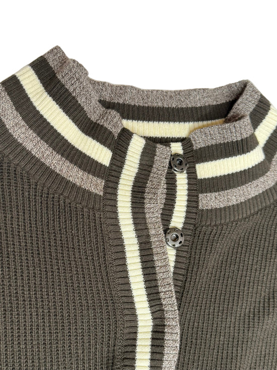 Close-up of a gray and white striped sweater with buttons on a light gray background