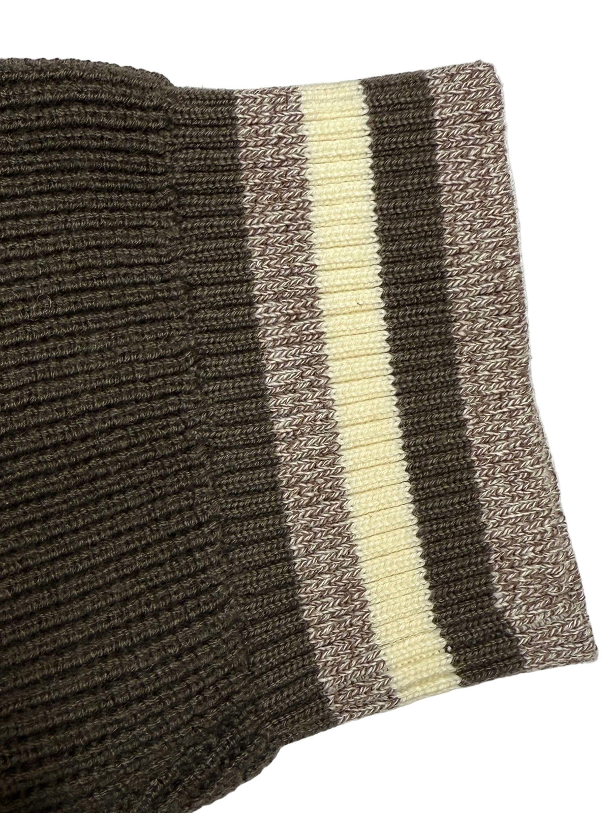 Close-up of a knitted fabric with brown and cream stripes on a white background