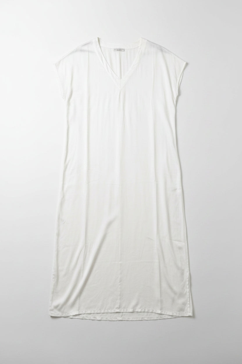 White sleeveless dress on a hanger against a white wall.