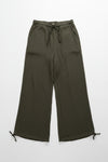 Green pants on a hanger against a white wall