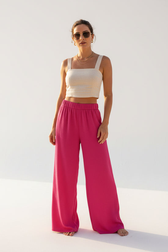 A woman wearing pink pants at the beach