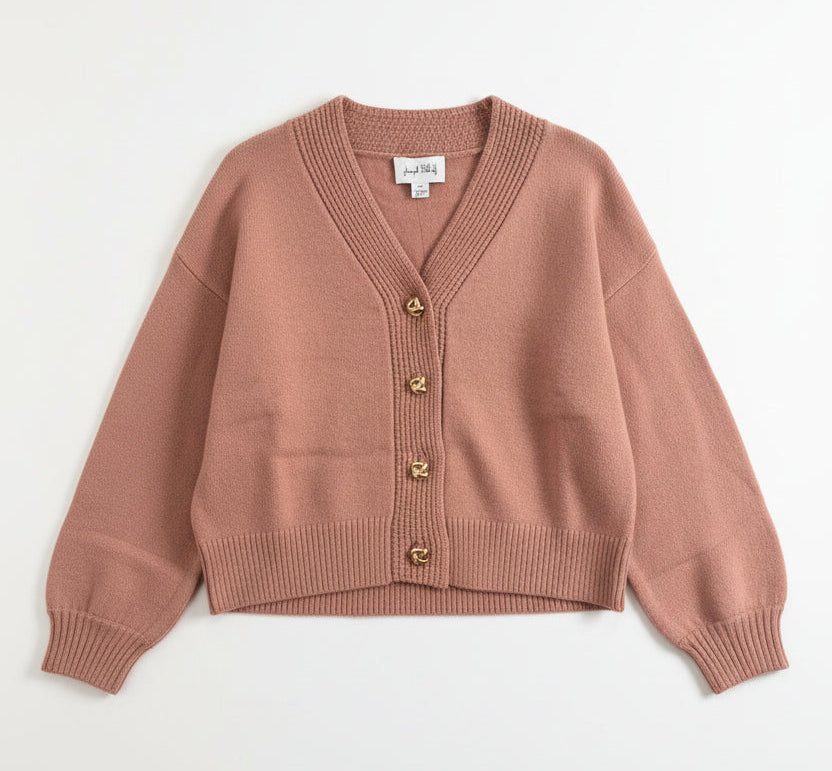 Rose cardigan on a hanger against a light background