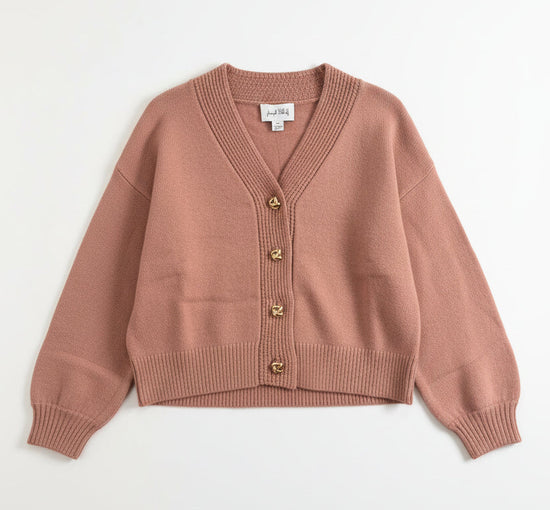 Rose cardigan on a hanger against a light background